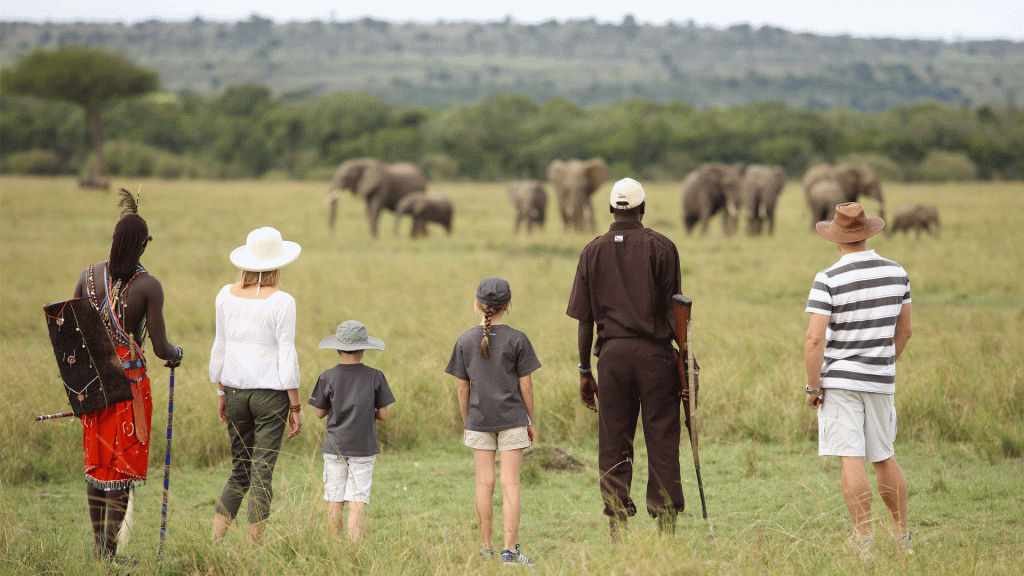 children on a nature walk safari in company of their parents and a game ranger. at Masai Mara Game reserve Kenya. 
