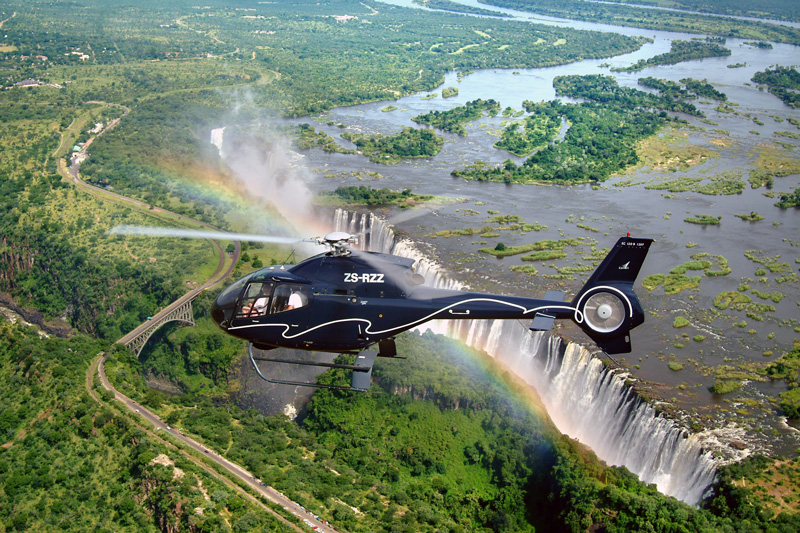 A helicopter with tourist takes a flight over victoria falls.
