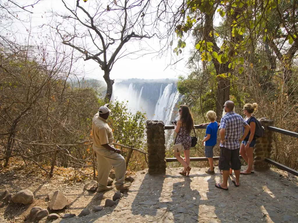 A local guide with Tourists at a victoria falls view point Zambia.
