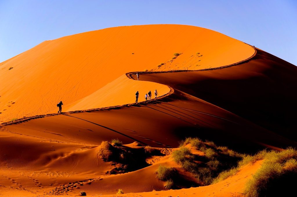 Tourists hiking one of the highest sand dunes at Sossusvlei Namibia