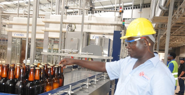 An employee of Nile breweries checking beer bottles before packaging Jinja Uganda