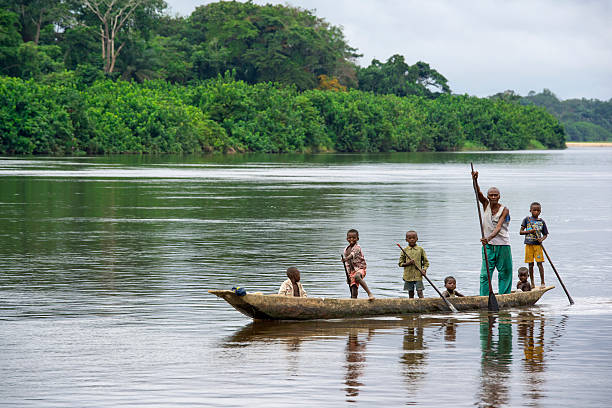 Man and children traveling along river Congo Africa