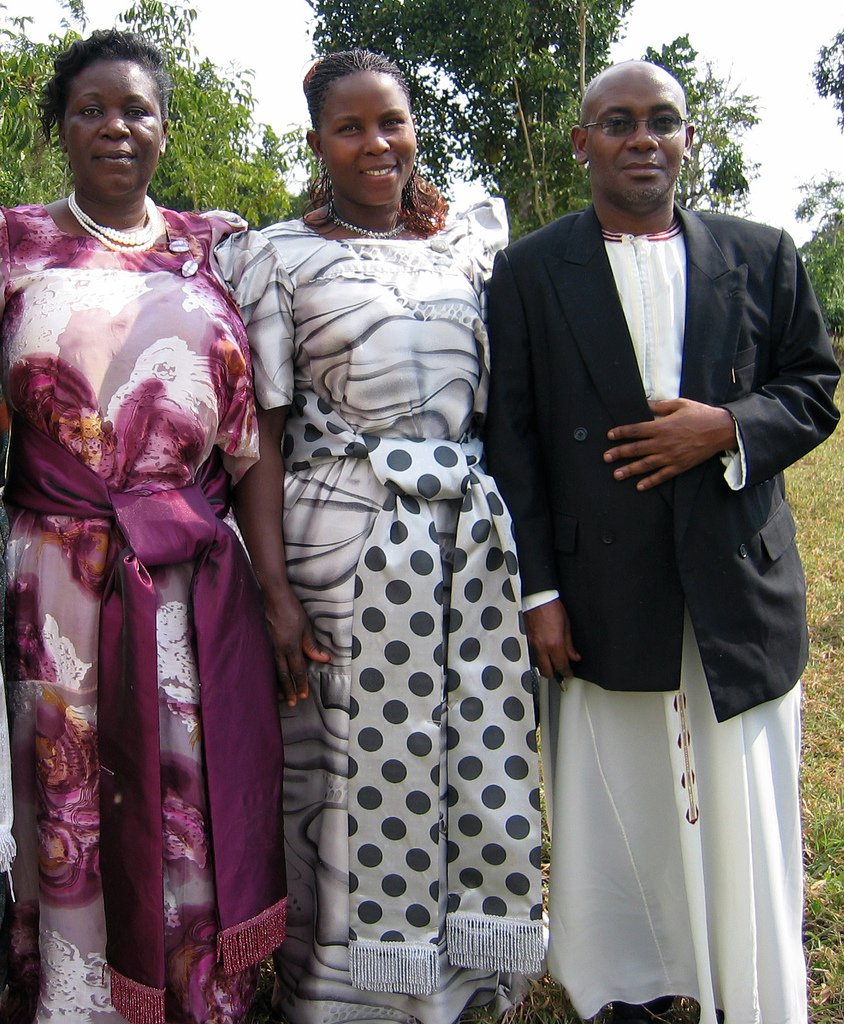 Two Baganda Women dressed in Gomesi attire and a Muganda man dressed in Kanzu attire Mpigi Uganda