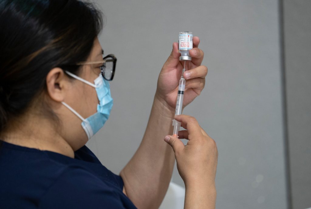 Doctor preparing vaccine shot.